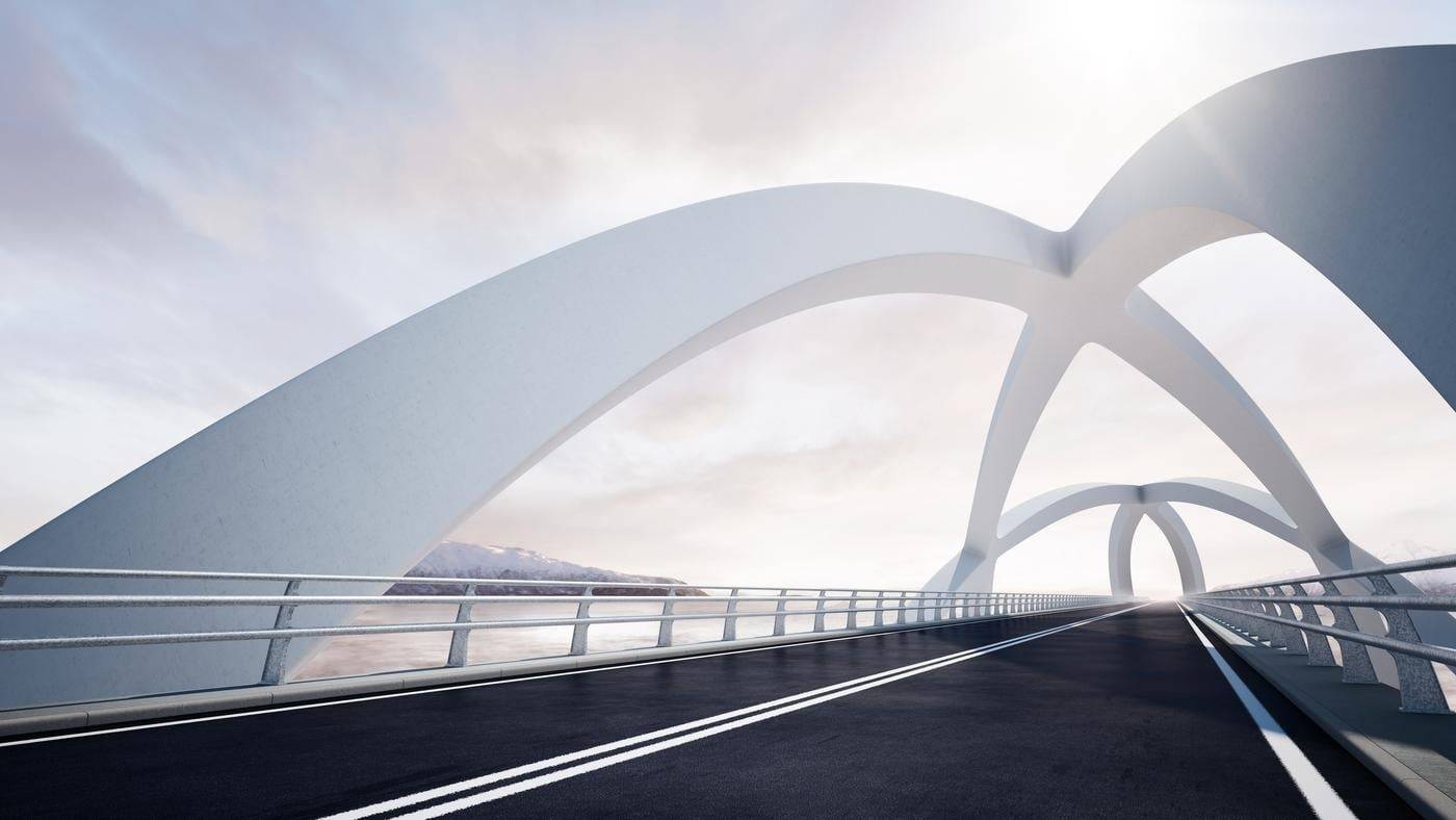 Modern curved architectural white bridge, against a backdrop of a river and mountain landscape on the left.