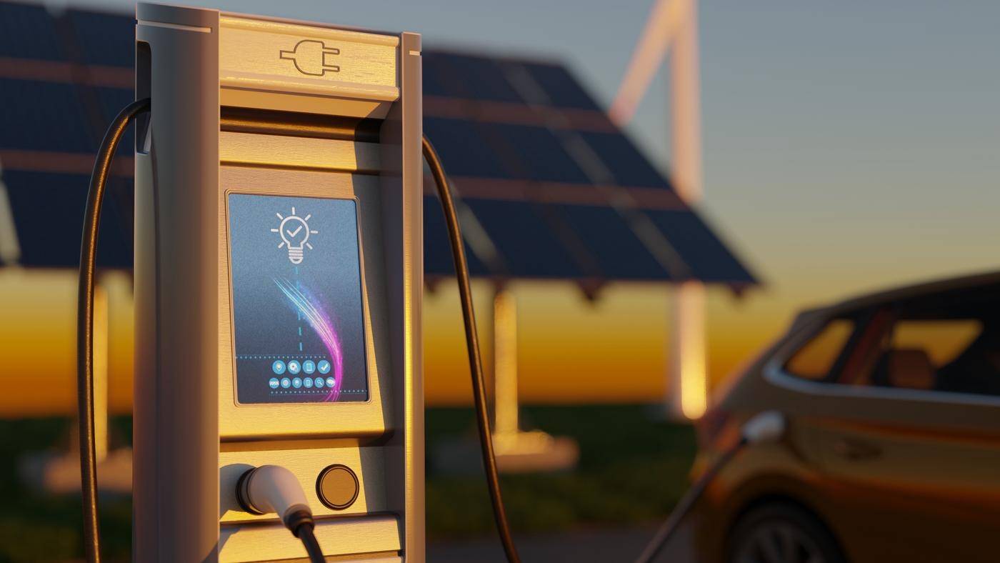 Electric car charging with wind turbines and solar panels in the background.