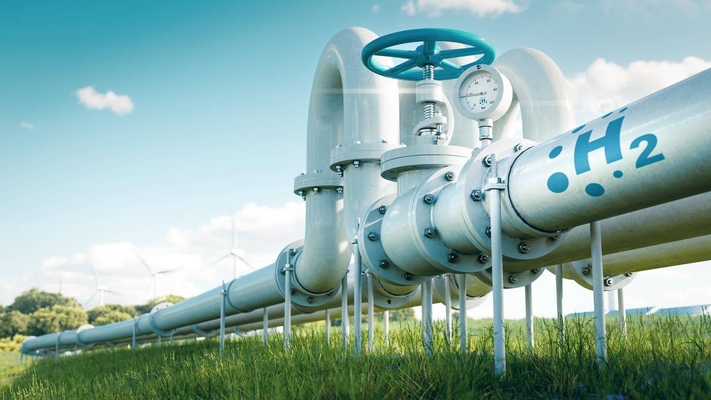 3D render of hydrogen pipelines in a field with wind turbines in the distance.