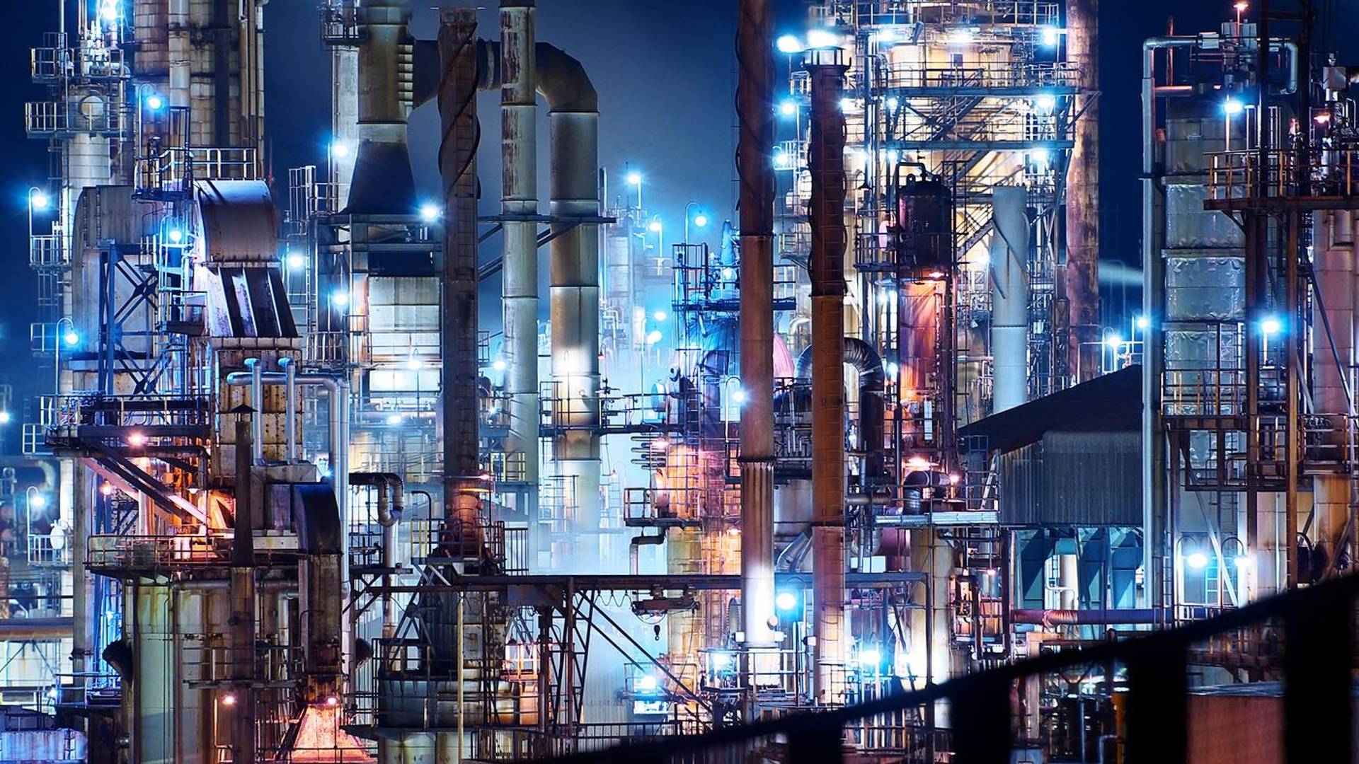 Vast illuminated refinery at night. 