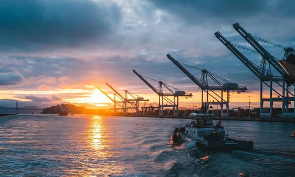 OA container ship leaving an empty port at dusk.
