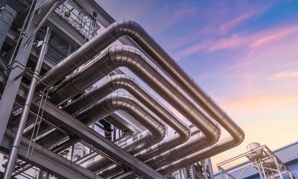 The pipe of factory, close-up of industrial steel pipelines at oil-refinery plant and sky.