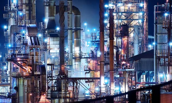 Vast illuminated refinery at night. 