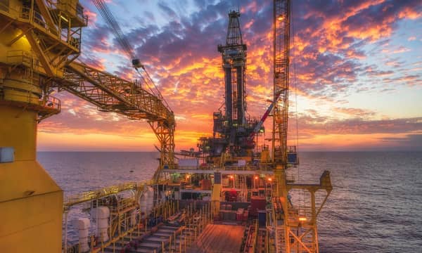 A view from aboard an oil rig in the ocean at sunset.