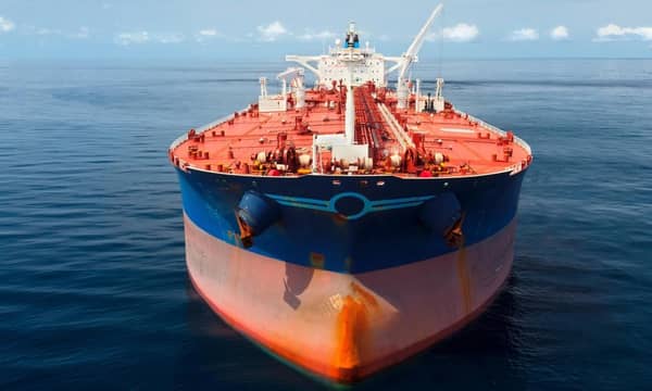 A close-up of a large red and blue oil tanker in the ocean.