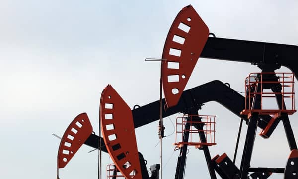 A group of oil pumps against a cloudy sky.
