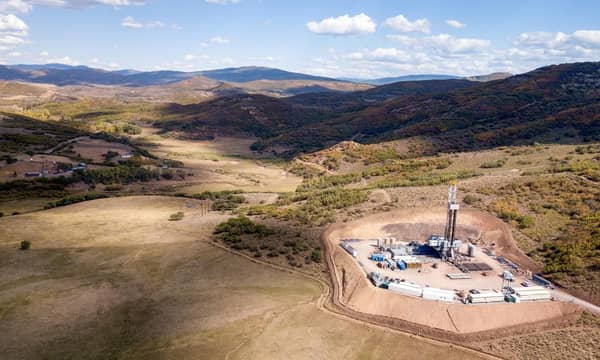 An aerial view of a drilling rig in the mountains.