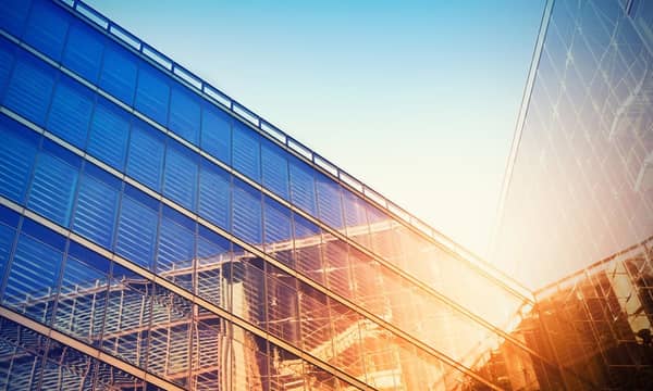 Modern building bathed in evening sunlight, reflecting against the glass.