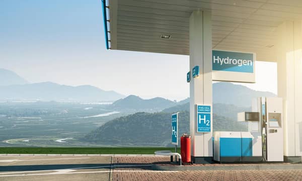 A covered hydrogen fuel cell vehicle charging station in the mountainous countryside.