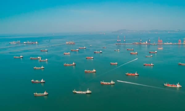 Aerial view many oil ship tanker park on the sea waiting load or unload oil at loading dock from refinery. Energy or transportation industry concept.