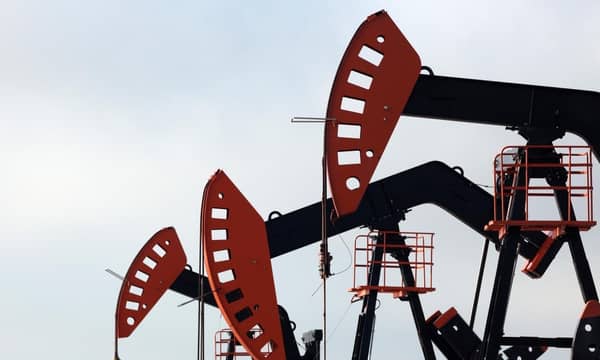 A group of oil pumps against a cloudy sky.