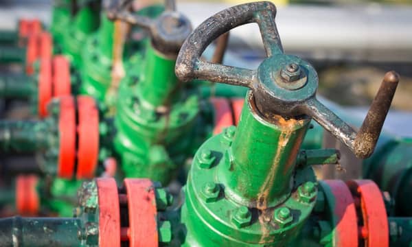 A group of green and red valves on a pipeline.