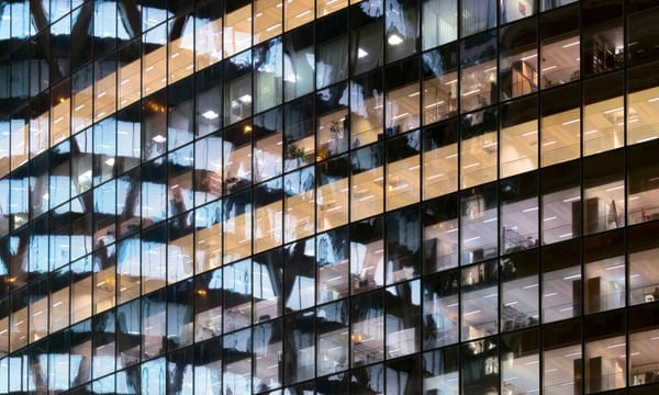 Reflection of illuminated office building in glass office facade in Paris, France.