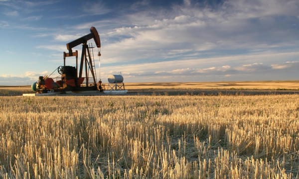 An oil pump in a large crop field.