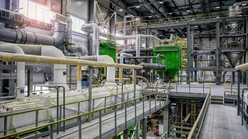 A large factory with pipes, vents and equipment, across multiple levels.