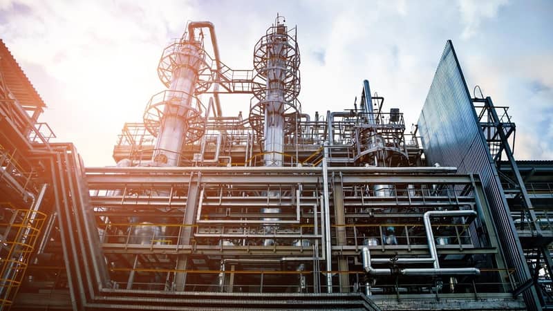 The exterior of an industrial plant with several levels and multiple criss-crossing pipes, tubes and platforms.
