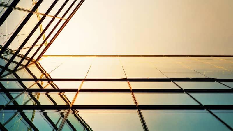 Modern angled corporate building,  the sunlight reflecting against the glass.