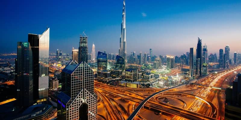 Dusk view of awesome Dubai's skyline, aerial view of the city at blue hour and sprawling intersections.