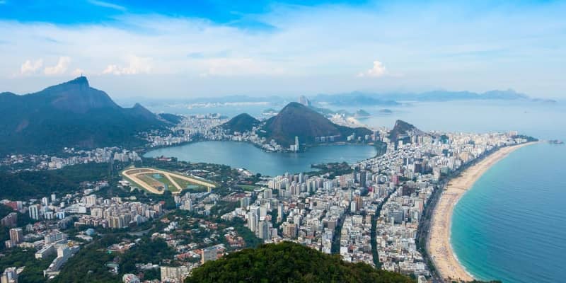 Copacabana Beach, apartment and commercial buildings, with mountains on a clear blue day. Rio de Janeiro, Brazil.