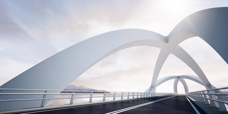Modern curved architectural white bridge, against a backdrop of a river and mountain landscape on the left.