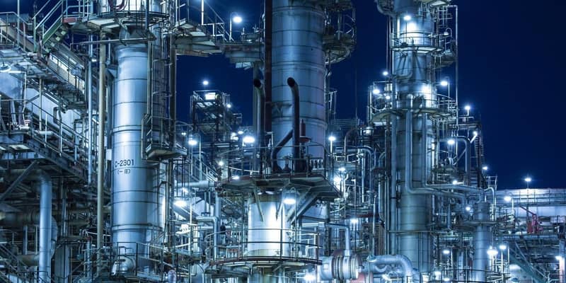 An illuminated gas/oil refinery at night. 