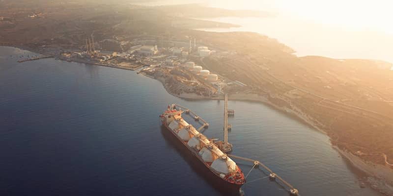 High angle view of a Gas Tanker moored to the jetty close to a power station during a foggy sunrise.