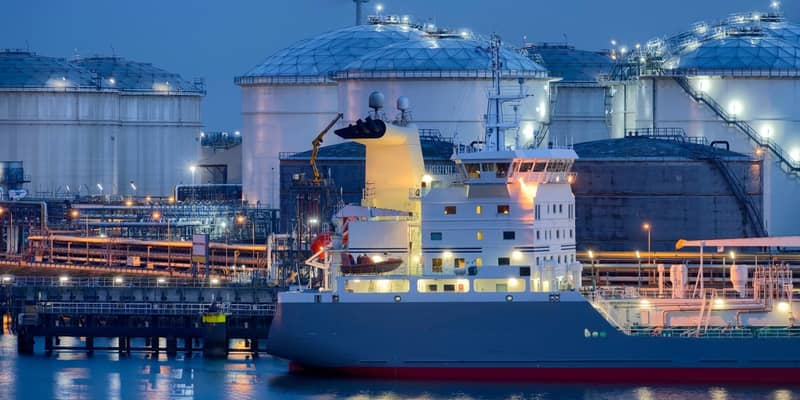 Liquid Natural Gas storage tanks and tanker at dusk, Port of Rotterdam.