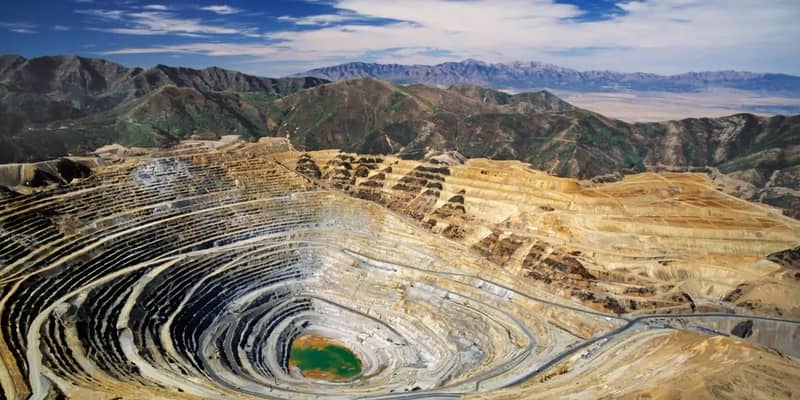 A large quarry pit in the middle of a mountain range.