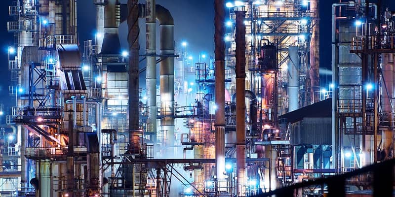 Vast illuminated refinery at night. 