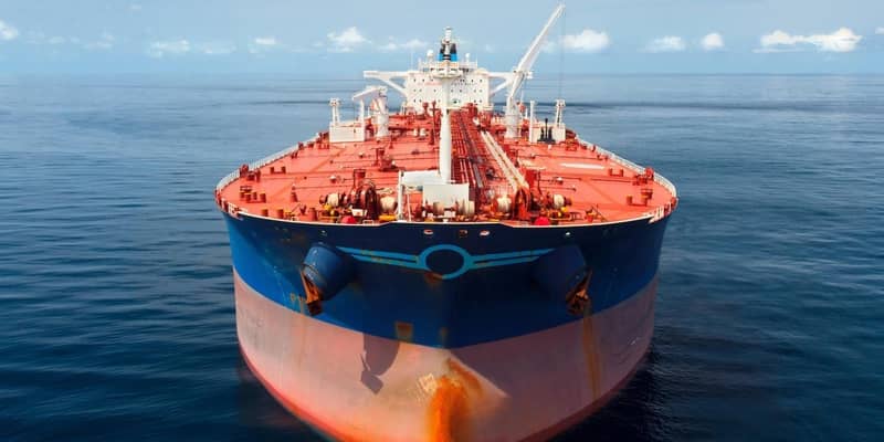 A close-up of a large red and blue oil tanker in the ocean.