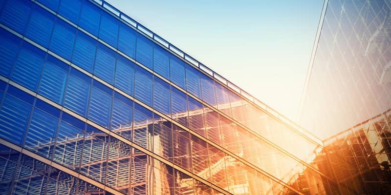 Modern building bathed in evening sunlight, reflecting against the glass.