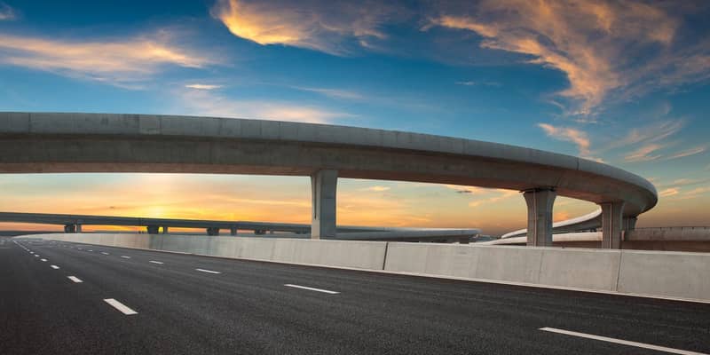 Asphalt road of a crossover overpass under a clear sky in the evening.