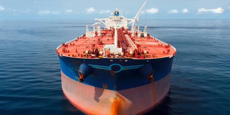 A close-up of a large red and blue oil tanker in the ocean.