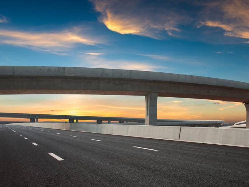 Asphalt road of a crossover overpass under a clear sky in the evening.