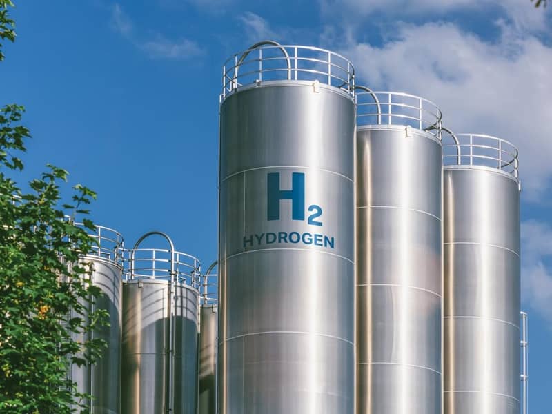 Several hydrogen fuel storage cylinders, against a blue sky.