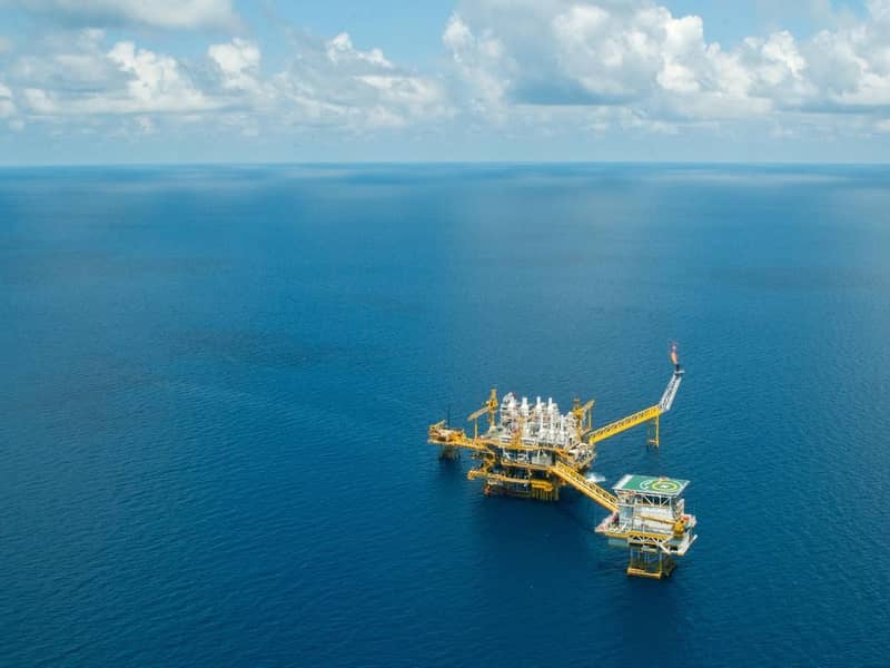 An aerial view of an oil rig in the open ocean.