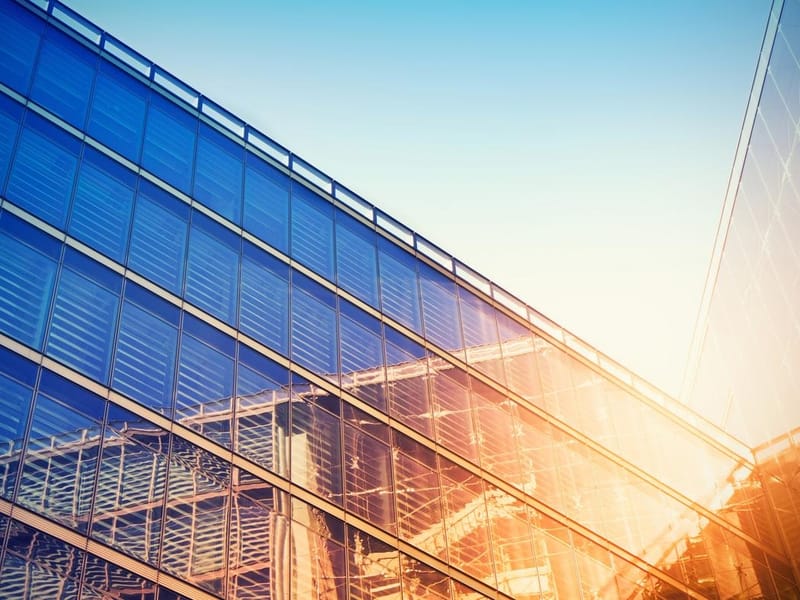 Modern building bathed in evening sunlight, reflecting against the glass.