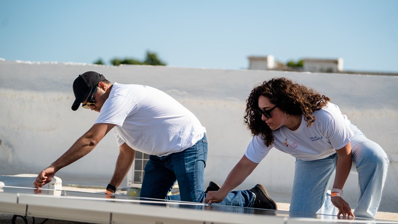 Image shows WoodMac volunteers working on a solar installation