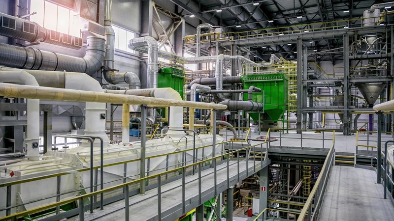 A large factory with pipes, vents and equipment, across multiple levels.