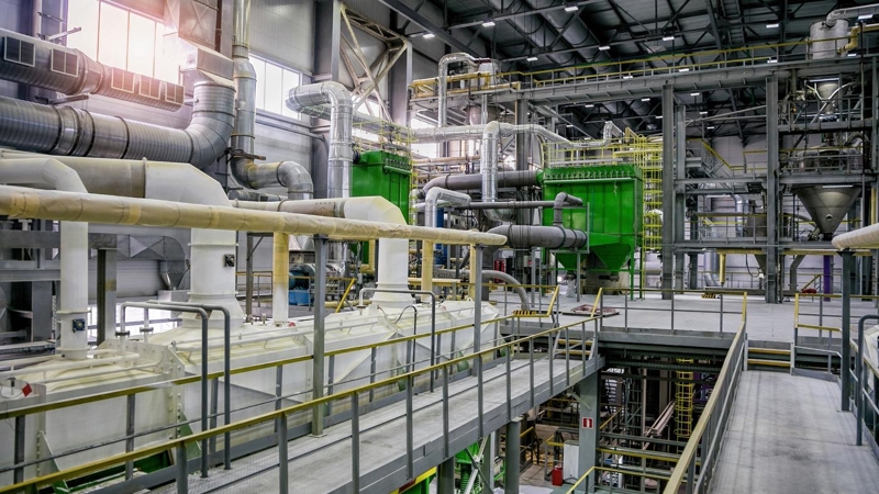 A large factory with pipes, vents and equipment, across multiple levels.