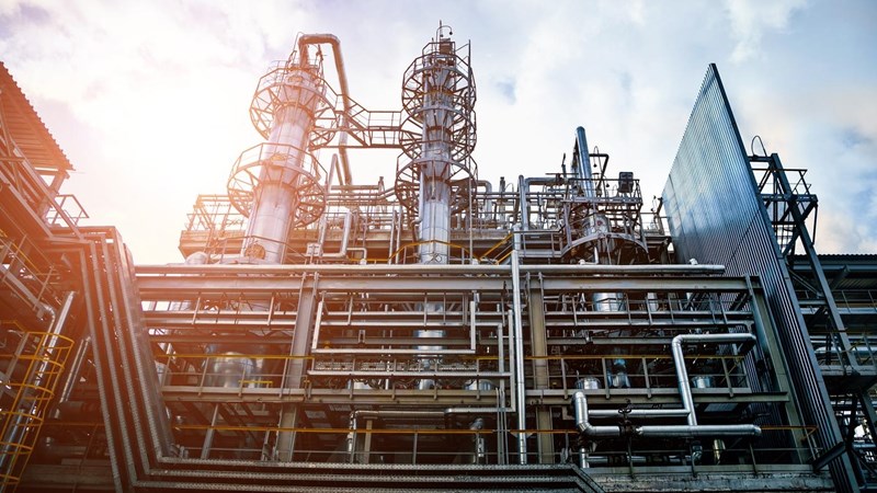 The exterior of an industrial plant with several levels and multiple criss-crossing pipes, tubes and platforms.