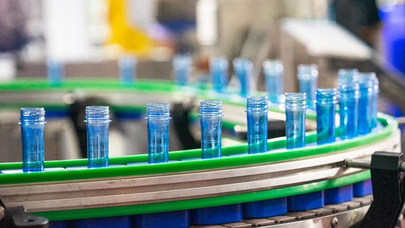 A batch of empty blue plastic tubes, going around on a conveyor belt.