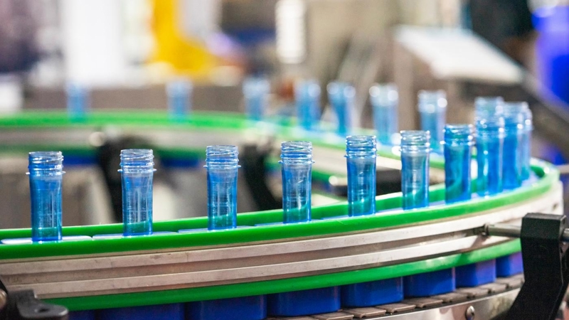 A batch of empty blue plastic tubes, going around on a conveyor belt.