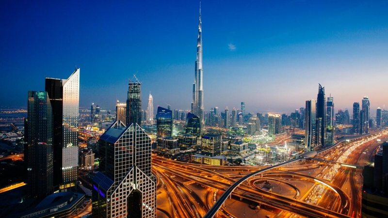 Dusk view of awesome Dubai's skyline, aerial view of the city at blue hour and sprawling intersections.