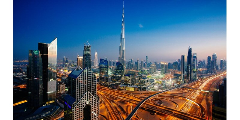 Dusk view of awesome Dubai's skyline, aerial view of the city at blue hour and sprawling intersections.