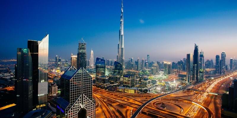 Dusk view of awesome Dubai's skyline, aerial view of the city at blue hour and sprawling intersections.