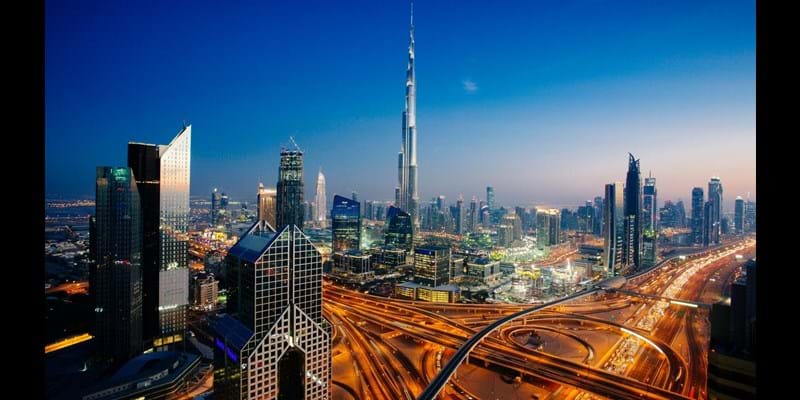 Dusk view of awesome Dubai's skyline, aerial view of the city at blue hour and sprawling intersections.