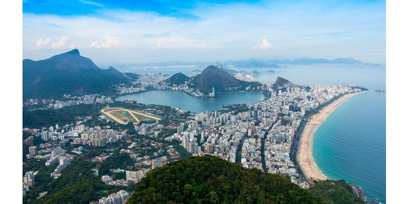 Copacabana Beach, apartment and commercial buildings, with mountains on a clear blue day. Rio de Janeiro, Brazil.