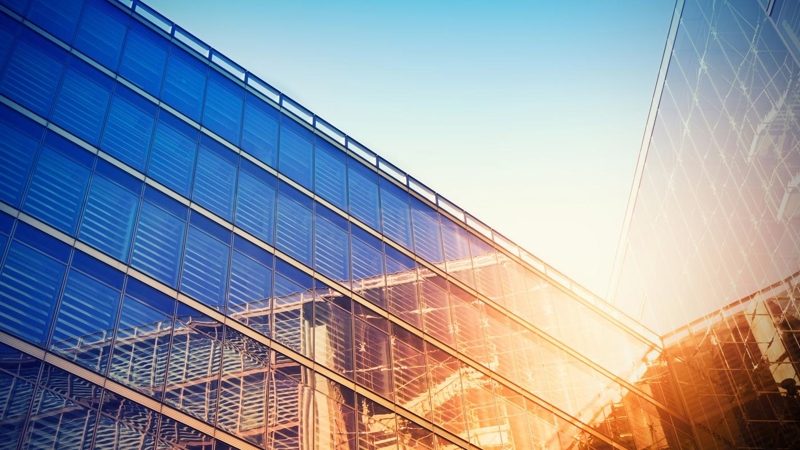 Modern building bathed in evening sunlight, reflecting against the glass.