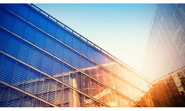 Modern building bathed in evening sunlight, reflecting against the glass.